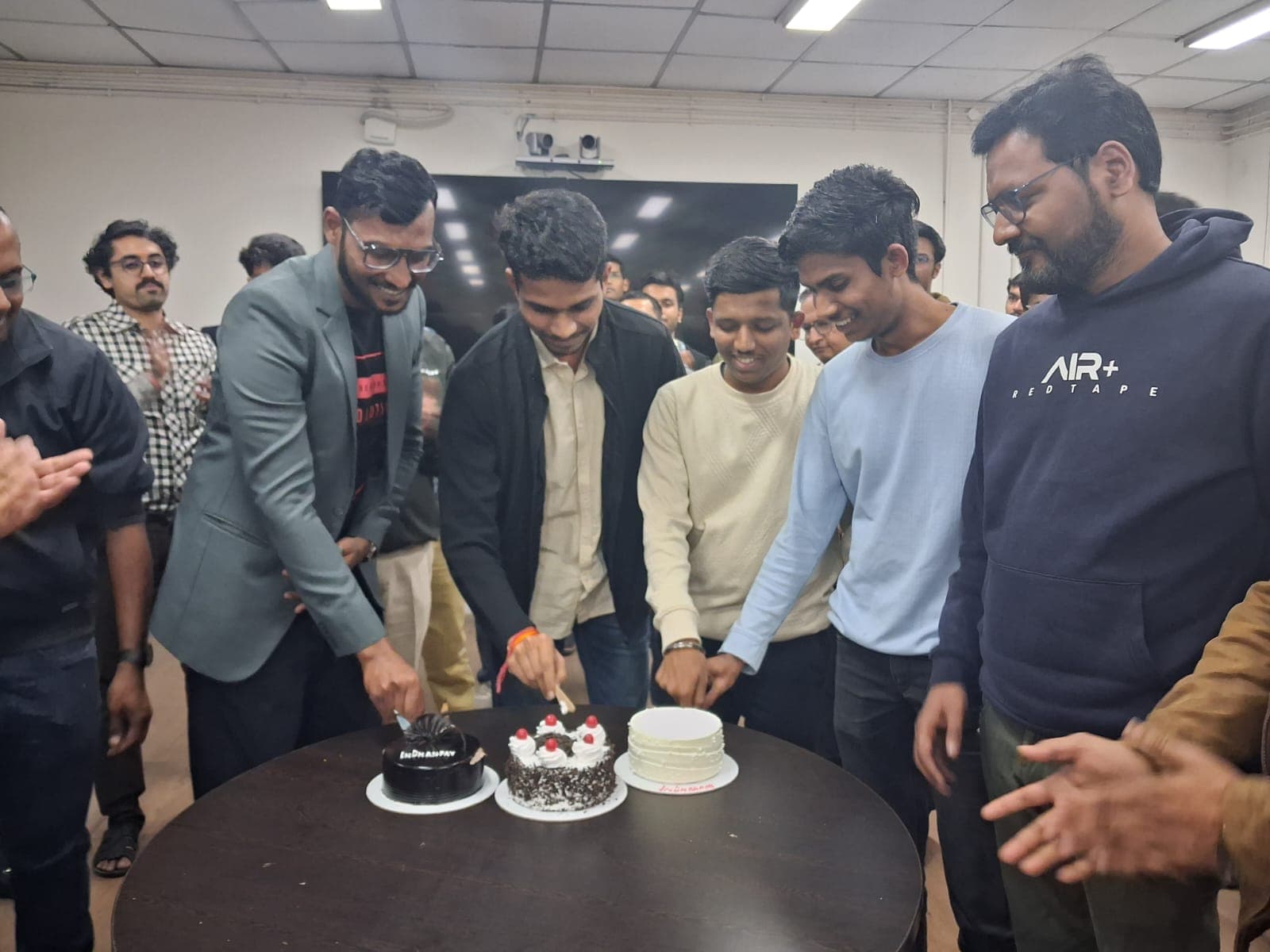 InDhanPay team celebrating milestone with cake cutting